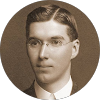 Sepia-toned vintage portrait of a man wearing glasses and a suit, circa early 20th century.